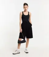 Musculosa básica de calce ajustado confeccionada en tejido rib acanalado. Presenta escote redondo y breteles medios, ofreciendo un diseño versátil y cómodo.
