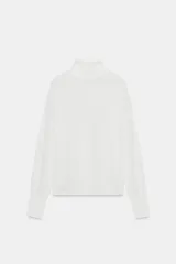 Jersey de punto extrafino con cuello subido y manga larga con sisa ancha que se estrecha hacia la muñeca.