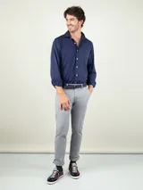 Pantalón chino de hombre color azul marino, de corte slim fit, confeccionado en gabardina de algodón, con bolsillos laterales y traseros, y cierre frontal de cremallera y botón.
