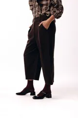 Pantalon de corte amplio y silueta relajada, color chocolate, con cintura alta, pinzas delanteras y bolsillos laterales.
