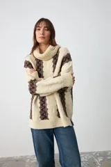 Sweater de punto grueso con cuello tortuga, diseño de rayas verticales en color crudo y marrón, de corte holgado y manga larga.