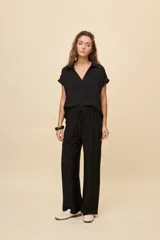 Pantalón gris de corte amplio y silueta fluida, con cintura elástica y cordón ajustable.