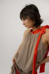 Vestido largo color marrón con detalles en tono marfil, escote halter y lazo largo en el cuello.
