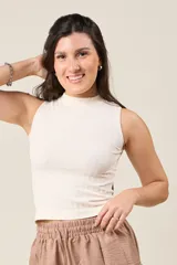 Musculosa de punto acanalado color crudo, con cuello alto y corte ajustado.