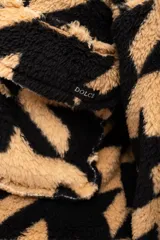 Campera corta de polar color beige con estampado de estrellas negras, cuello alto y cierre frontal.