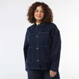 Chaqueta vaquera de corte largo y holgado, color azul oscuro con costuras en contraste. Presenta cuello clásico, cierre frontal con botones metálicos y dos grandes bolsillos frontales de parche.