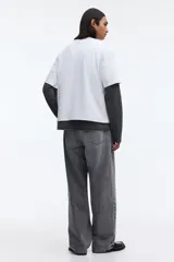 Remera blanca boxy de punto liviano de algodón, con hombros caídos, cuello redondo acanalado y corte oversized.