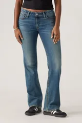 Jeans de mujer de tiro bajo, color azul medio con efecto lavado, corte bootcut y cierre de botón y cremallera.