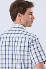 Camisa de manga corta a cuadros en tonos blanco, azul y gris, con cuello abotonado, bolsillo en el pecho y cierre frontal con botones.