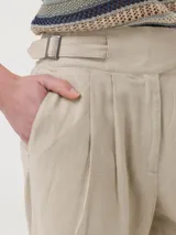 Pantalon recto de lino organico y viscosa color crema, con tiro alto, bolsillos laterales y detalle de hebillas ajustables en la cintura.