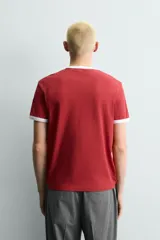 Camiseta roja de corte regular fit, con cuello redondo y mangas cortas. Presenta un estampado frontal con la frase "Los Angeles" en blanco y acabados de vivo en contraste blanco en cuello y mangas.