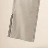 Pantalón flare de cuero vacuno en color hueso, con tiro alto y diseño ajustado con abertura en los tobillos.