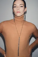 Collar largo con cadena dorada y colgante rectangular con múltiples joyas de diferentes tamaños.