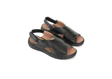 Sandalias de cuero negro con tiras cruzadas en el empeine, tira trasera ajustable con elástico y suela de poliuretano.