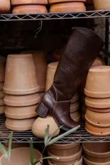 Bota de caña alta color marrón con textura símil reptil, taco cuadrado forrado en cuero y cierre lateral.