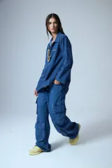 Pantalón jean azul denim de tiro medio, corte oversize y bolsillos cargo laterales y delanteros.