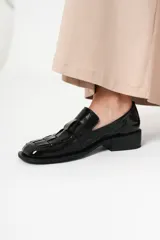 Mocasín de cuero charol negro con diseño enrejillado en la capellada y horma cuadrada.