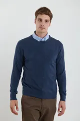 Sweater de tejido liso color naranja melange, con cuello redondo y puños y ruedo acanalados.