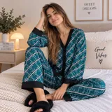 Pijama de dos piezas confeccionado en satén con estampado de gatos. Incluye una camisa de manga larga con cuello en V, solapas y cierre frontal de botones con detalles en rosado, y un pantalón largo a juego.