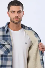 Campera tipo leñadora de viyela a cuadros, con interior forrado en corderito para mayor abrigo. Presenta cierre frontal con botones, cuello clásico y dos bolsillos frontales con solapa y botón.