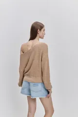 Sweater de punto color tostado, de calce relajado, con escote asimétrico decorado con ojalillos metálicos y mangas largas.