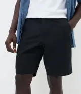 Bermuda slim de sarga color beige, con cintura con trabilla, cierre tradicional y bolsillos laterales.