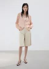 Camisa de lyocell semitransparente con estampado de rayas en tonos marrones y blancos, cuello camisero, manga larga y cierre frontal con botones.