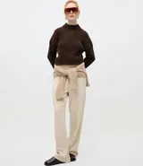 Suéter de punto texturizado con cuello alto, diseño oversized y mangas largas. Presenta una caída amplia y una superficie encorpada, ideal para un estilo moderno y acogedor.