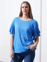 Blusa de mujer color azul vibrante con textura acanalada y pequeños patrones jacquard en relieve. Presenta un escote redondo y mangas cortas con vuelo.