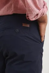 Pantalón de gabardina color verde medio, de corte slim fit, con bolsillos laterales y traseros.