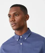 Camisa de manga larga para hombre, confeccionada en algodón con textura sutil. Presenta cuello con botones, cierre frontal abotonado y puños clásicos.