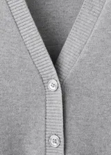 Cardigan gris de punto con escote en V, cierre frontal abotonado y mangas largas, diseño clásico y versátil.