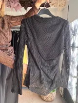 Blusa de manga larga marrón con diseño calado y textura acanalada, cuello alto drapeado y ajuste al cuerpo.