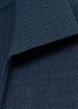 Vestido largo de punto fino color azul oscuro, con diseño entallado, sin mangas y cuello polo con escote en V.