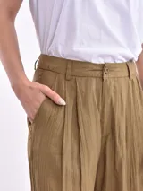 Pantalon de corte recto y tiro alto, con diseño de pinzas en la cintura y textura arrugada, en color oliva.