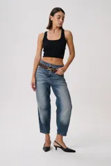 Pantalón jean de tiro medio y corte holgado, con lavado bicolor en efecto desgastado y terminación levemente fruncida en el bajo.