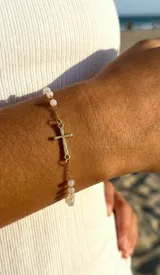 Pulsera tipo decenario de acero dorado con cuentas de cristal y dije de cruz.