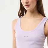 Conjunto de pijama de dos piezas en color lila, compuesto por una musculosa de canalé con detalle de puntillas y sutil bordado en el pecho, y un short con estampa a cuadros vichy y terminación festoneada en el ruedo.
