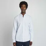 Camisa celeste de corte clásico, con cuello abotonado y mangas largas con puños abotonados.