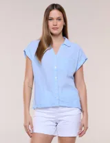 Camisa de lino de estructura recta, color beige con rayas verticales blancas. Cuenta con cuello solapa, escote en V abierto, abotonadura frontal, bolsillo plaqué en el pecho, mangas cortas de hombro caído y ruedo recto.