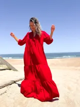 Vestido largo color rojo, con escote en V, mangas 3/4 abullonadas y corte escalonado con volantes.