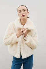 Campera corta de piel sintética en color crema, con cuello amplio tipo solapa y cierre frontal.