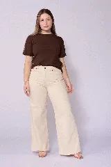 Jean de corte wide leg en color beige, con tiro alto y cierre frontal con botón y cremallera. Presenta un diseño de cinco bolsillos y costuras reforzadas.