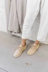 Zapatilla de diseño minimalista confeccionada en lana merino, con cordones al tono y suela de EVA. Presenta un estilo atemporal y versátil, ideal para uso diario.