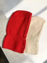Balaclava de tejido de punto en color rojo, con diseño envolvente y cierre frontal mediante botones metálicos.