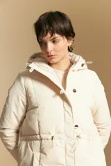 Campera acolchada de nylon en color crema, con capucha ajustable, cierre frontal con botones y cordón de ajuste en la cintura.