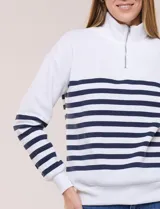 Buzo de frisa blanca con rayas horizontales azul marino, cuello alto con medio cierre y mangas largas.