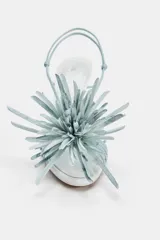 Sandalias de tacón alto y ancho, color blanco con tiras y detalle de flor decorativa en la parte delantera en tono celeste.