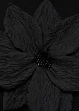 Top negro de tejido de punto fino con tirantes finos y detalle de maxi flor aplicada en el frente.