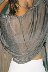 Top de cuello redondo y manga larga, confeccionado en tejido ligero con hilo metalizado de acabado dorado, con bajo recto y diseño holgado.